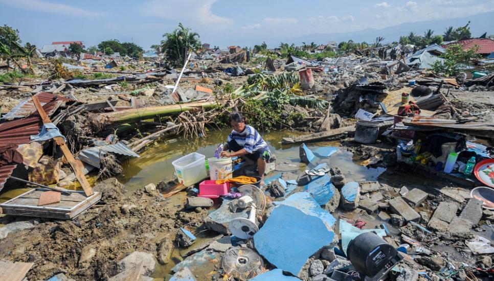 A woman sits amid the debris caused by the deadly Palu quake-tsunami that has so far claimed more than 1,400 lives